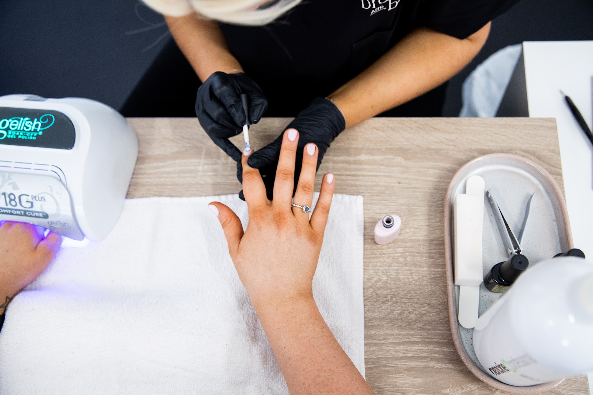 A gel manicure being finished under the lamp